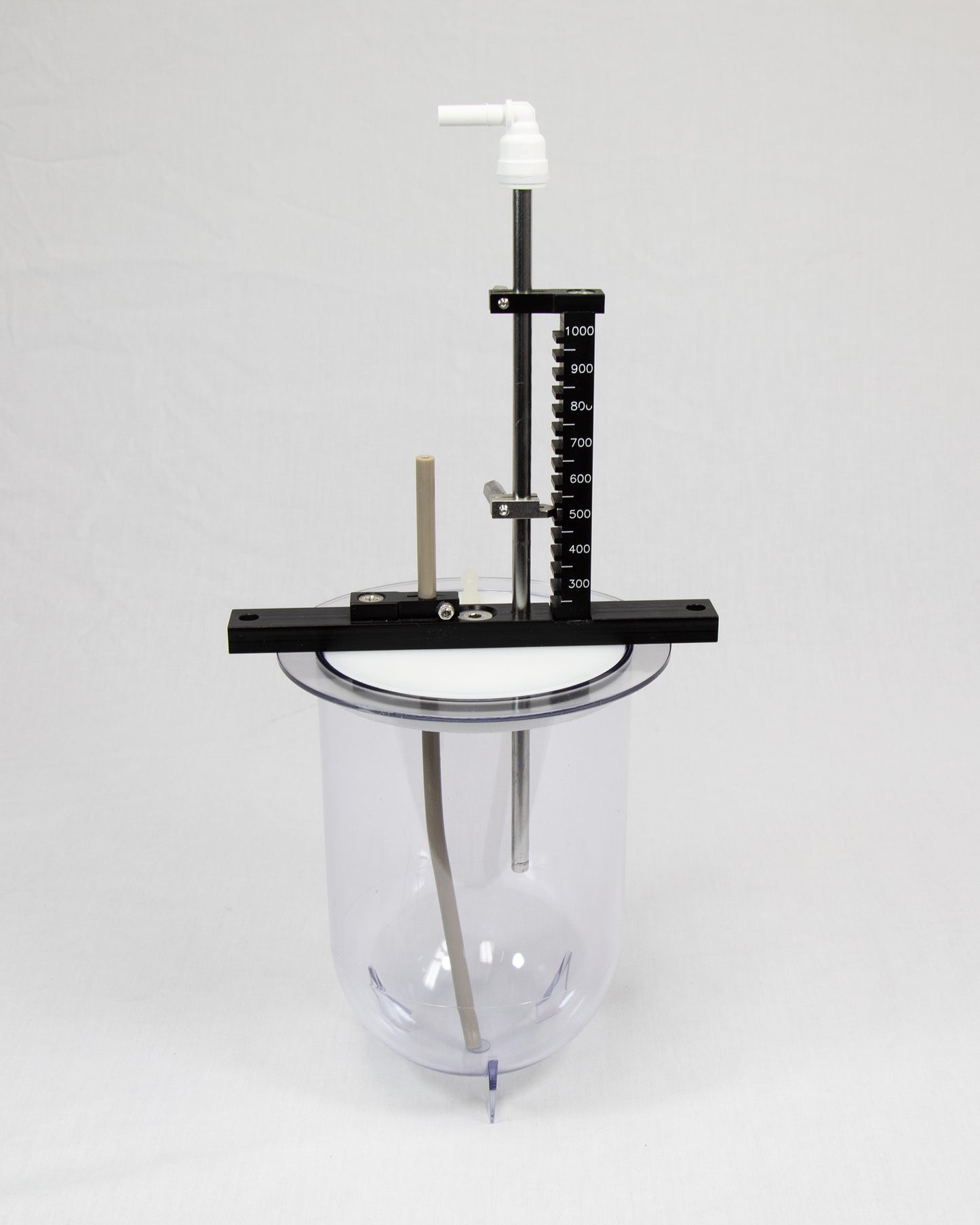 A glass jar on a metal stand, set against a plain white background, showcasing its transparent design and sleek structure.