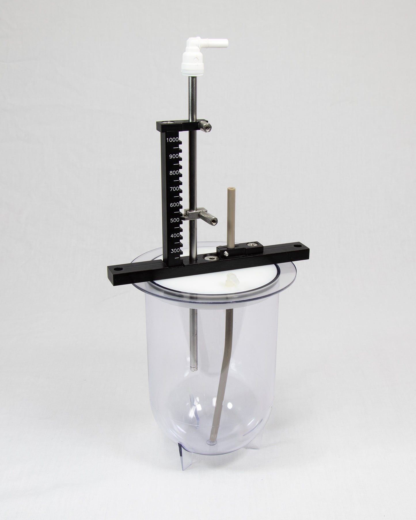 A glass jar on a metal stand, set against a plain white background, showcasing its transparent design and sleek structure.