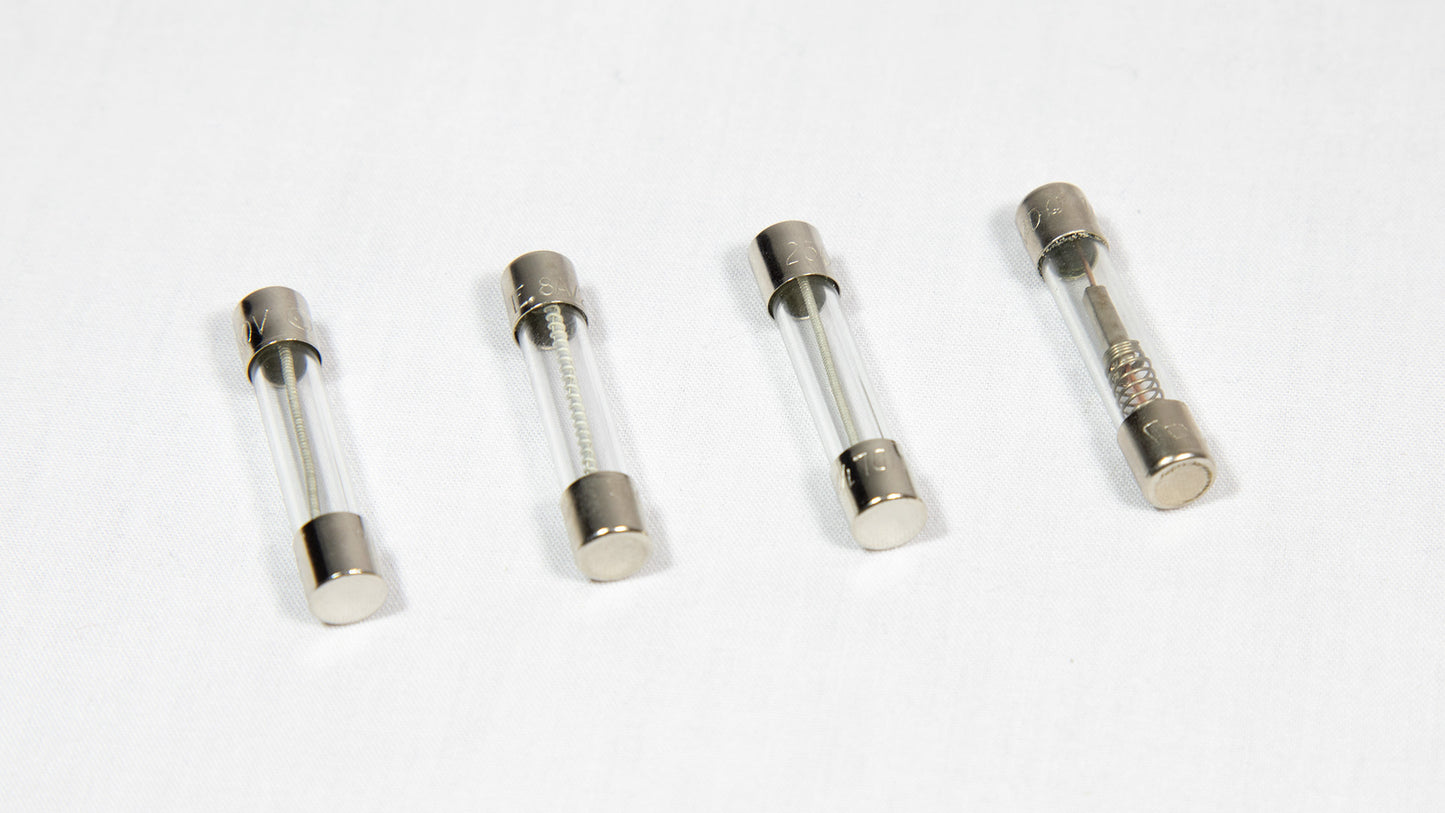 Four distinct electronic fuses arranged on a white surface.