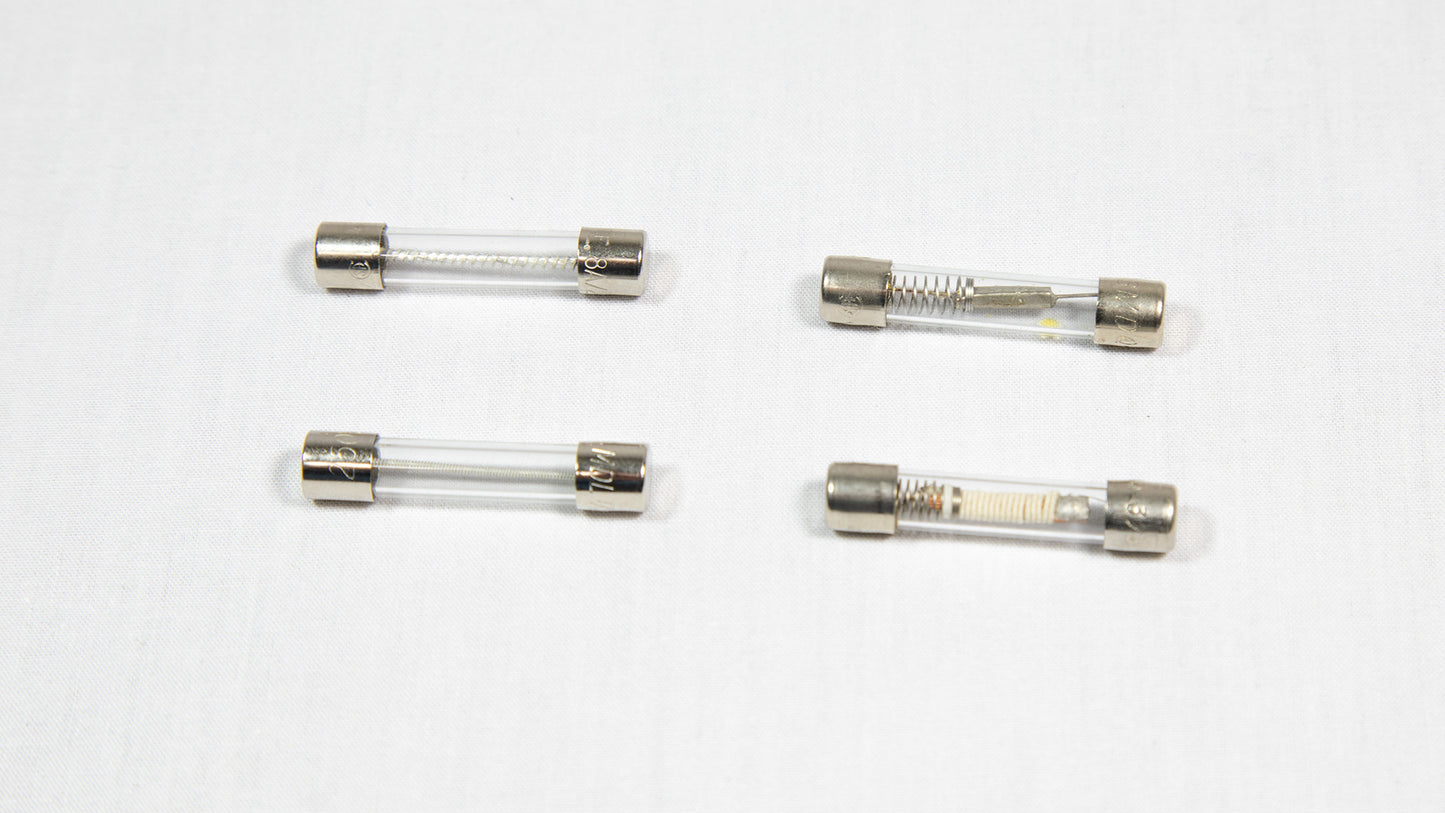 Four distinct electronic fuses arranged on a white surface.