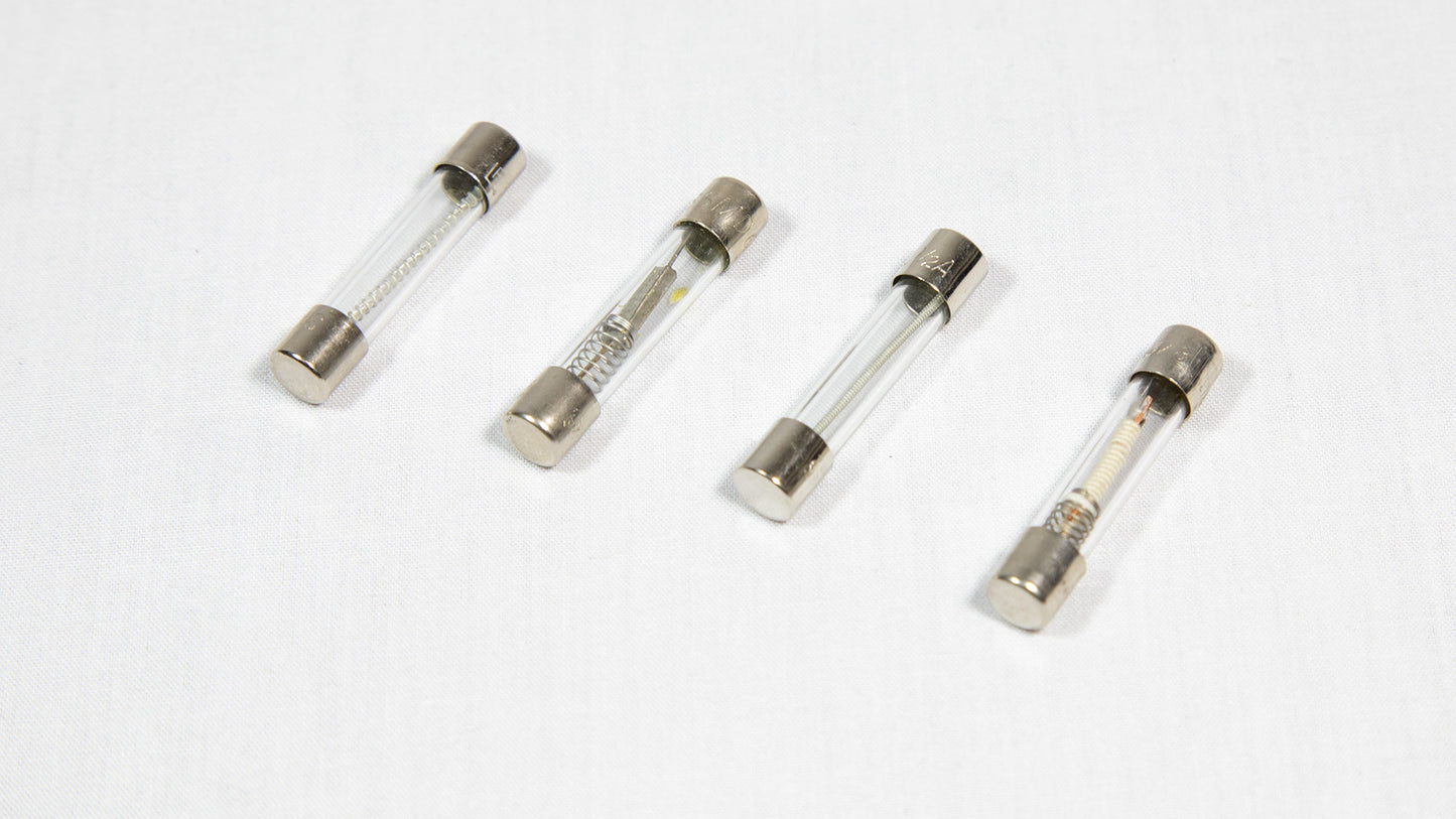 Four distinct electronic fuses arranged on a white surface.