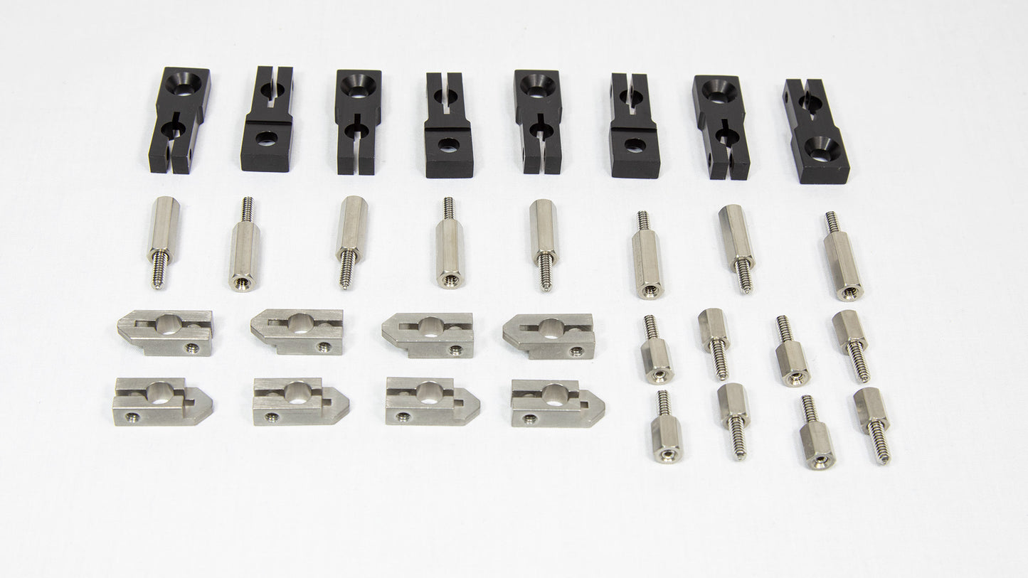 An assortment of metal parts and tools intended for machine assembly, organized on a table.