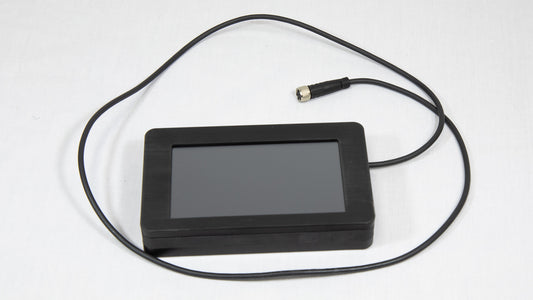 A small black screen with an attached cord, indicating its function may involve display in an instrument.