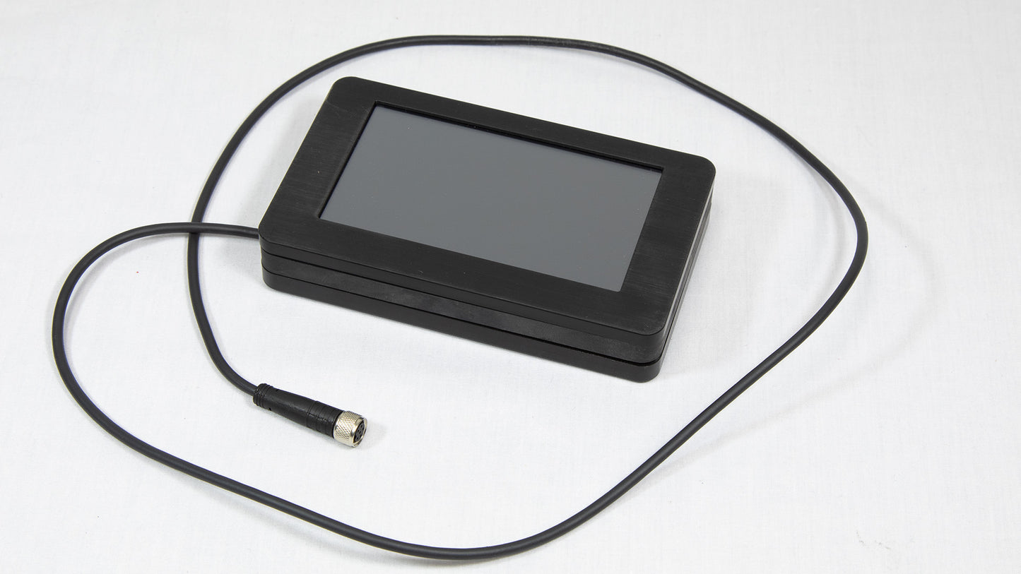 A small black screen with an attached cord, indicating its function may involve display in an instrument.