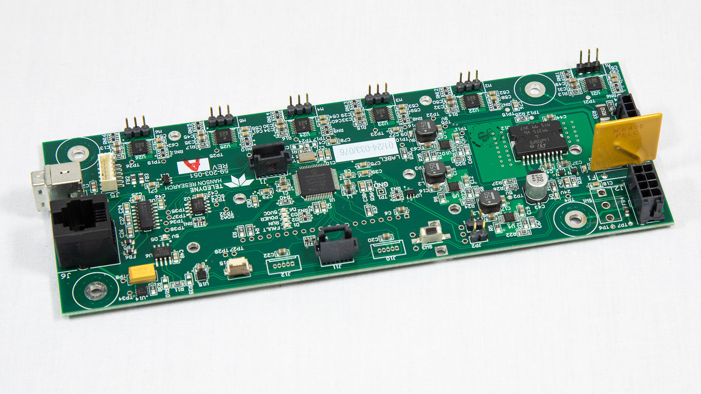A green electronic board displaying a yellow connector on its surface.