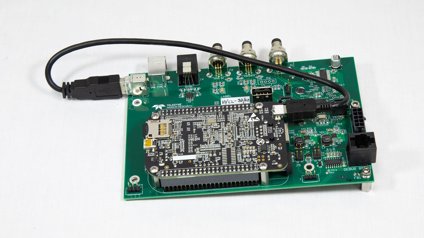 A miniature electronic board featuring an attached USB cable for power or data transfer.