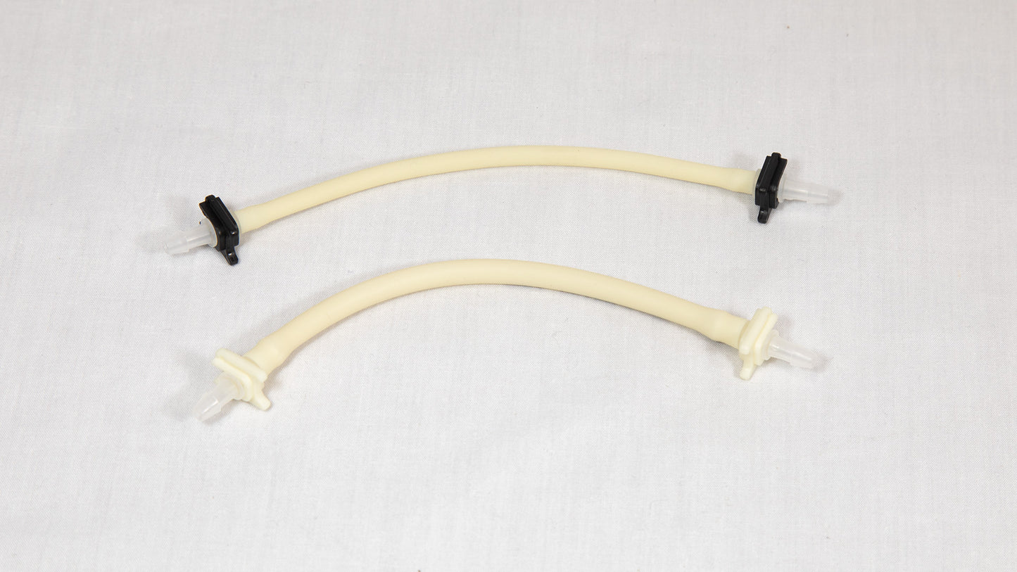 Two plastic tubes featuring connectors, positioned on a white surface.