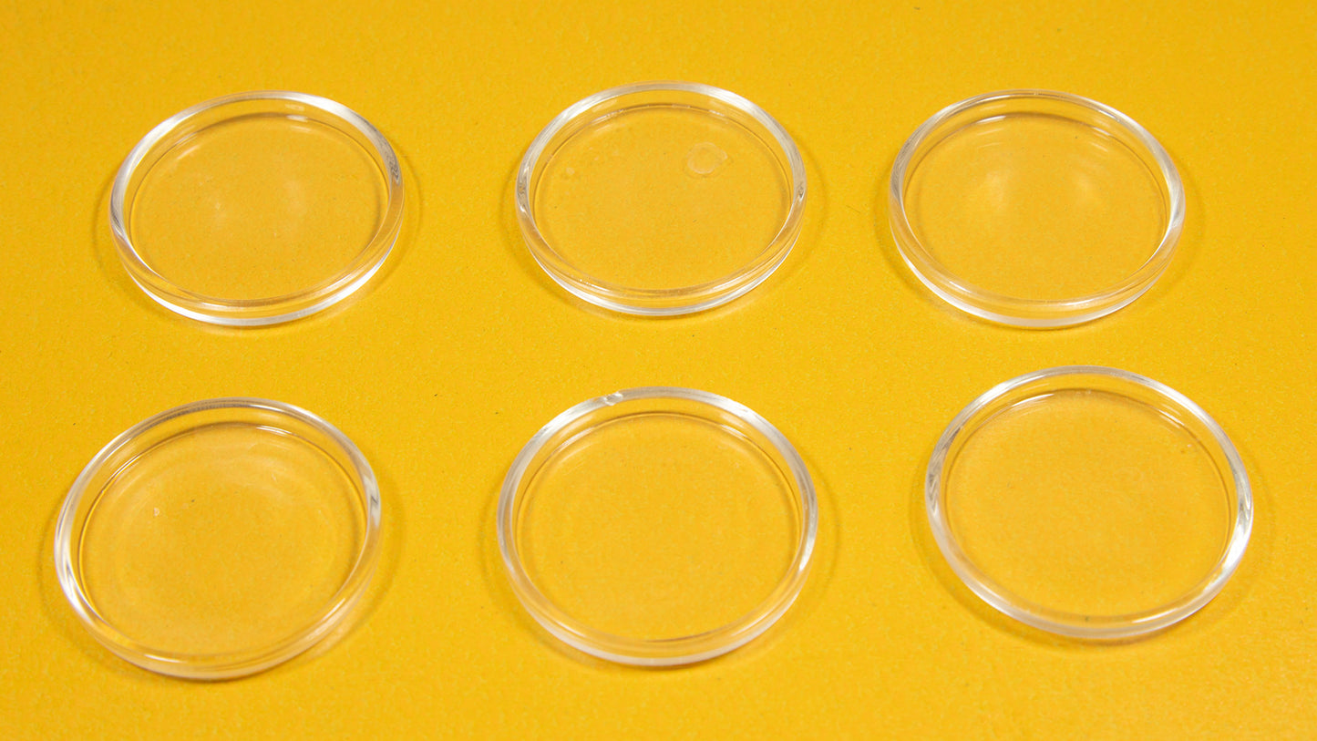 A collection of six clear oval plastic pieces displayed on a vibrant yellow background.