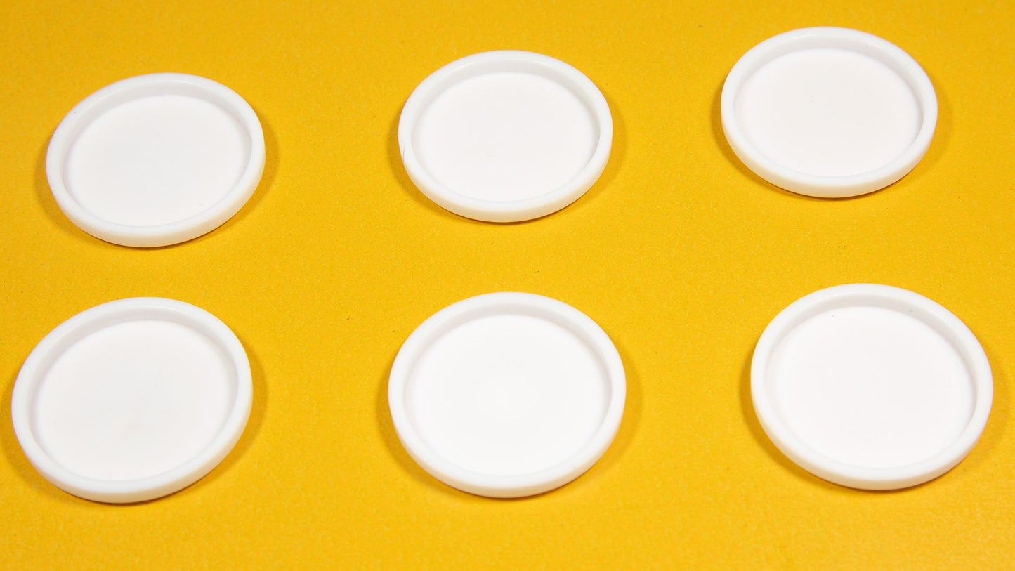 Six white round objects arranged on a bright yellow background.