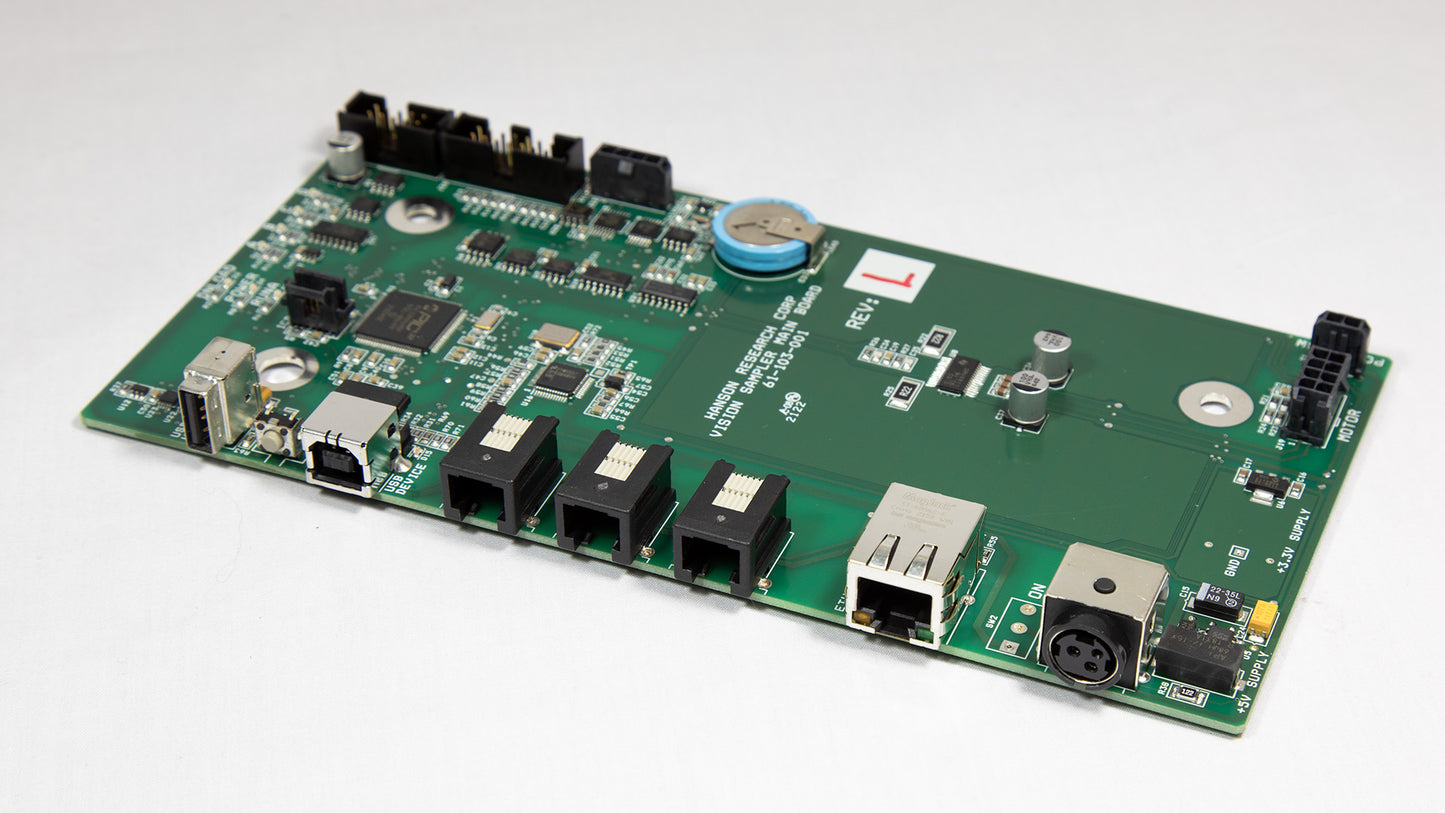 A green electronic circuit board with various components displayed on top.