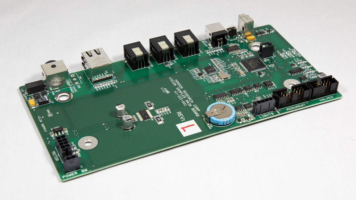 A green electronic circuit board with various components displayed on top.