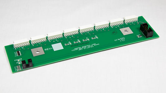 A green electronic circuit board with various components displayed on top.