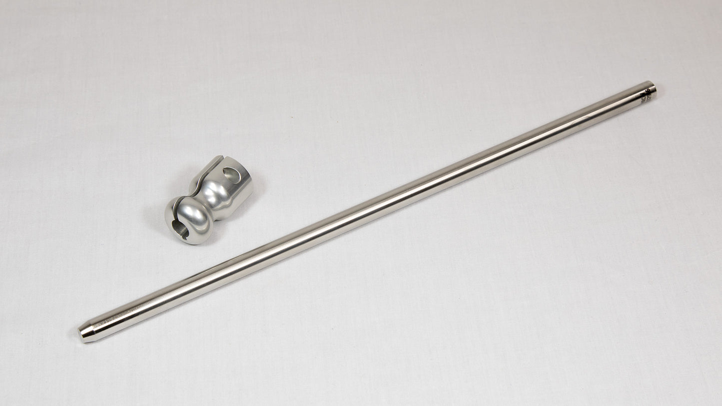 A stainless steel rod placed next to a clamp on a neutral background.