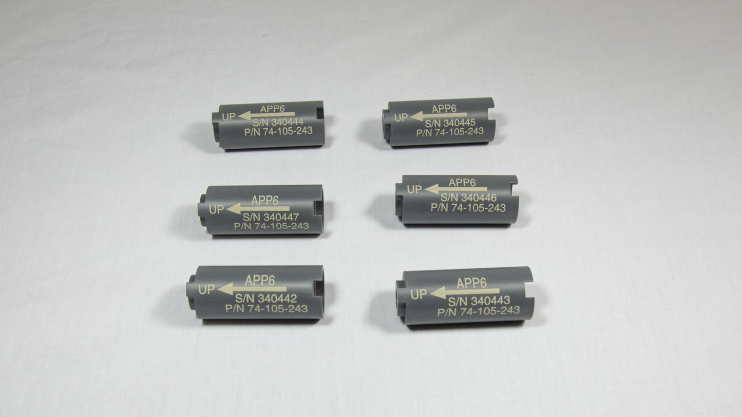 Six cylindrical black plastic objects, each with a perforation in the middle.