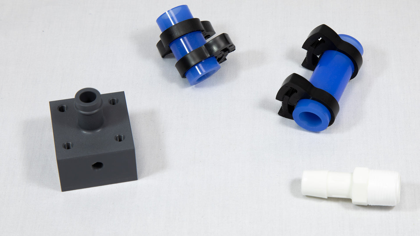 Sections of blue plastic tubing next to white and black connector components, showcasing their contrasting colors and materials.