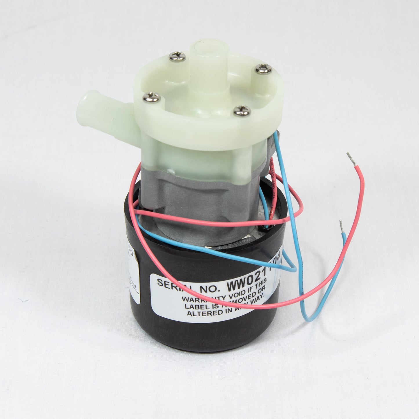 A small motor with multiple wires displayed on a white surface, showcasing its components and connections.