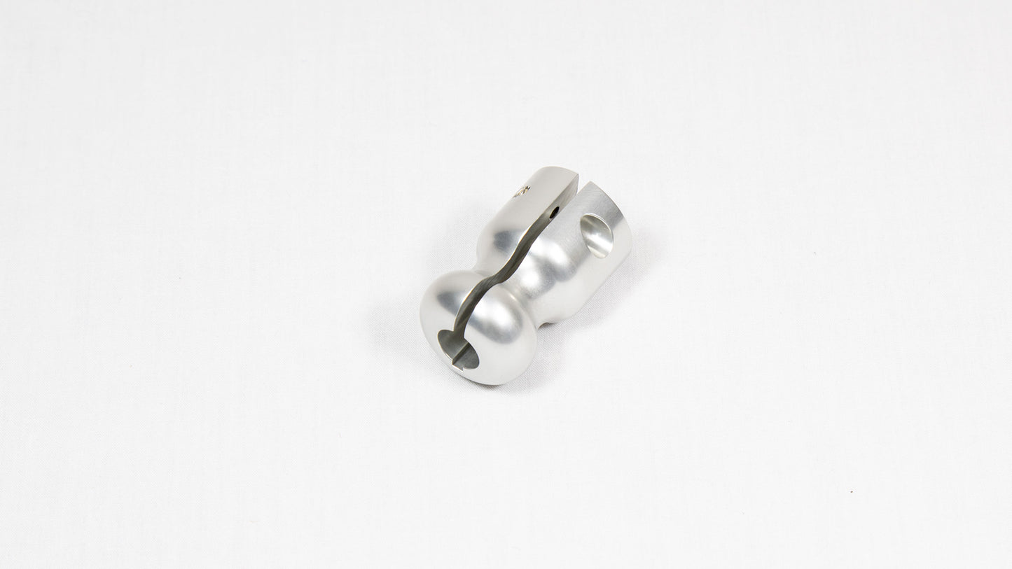 A stainless steel metal object positioned on a bright white surface, highlighting its design and texture.