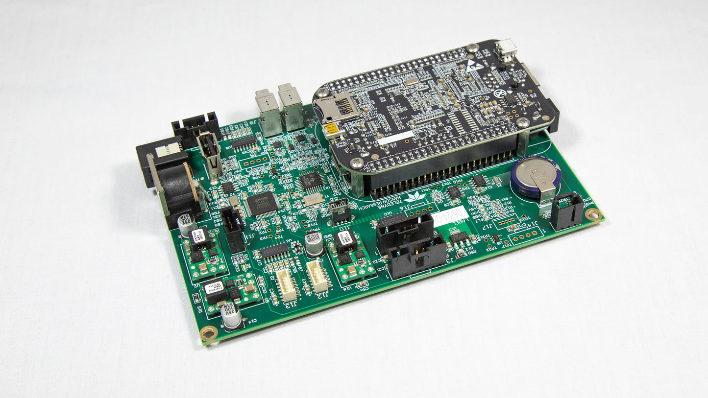 A green electronic circuit board with various components displayed on top.