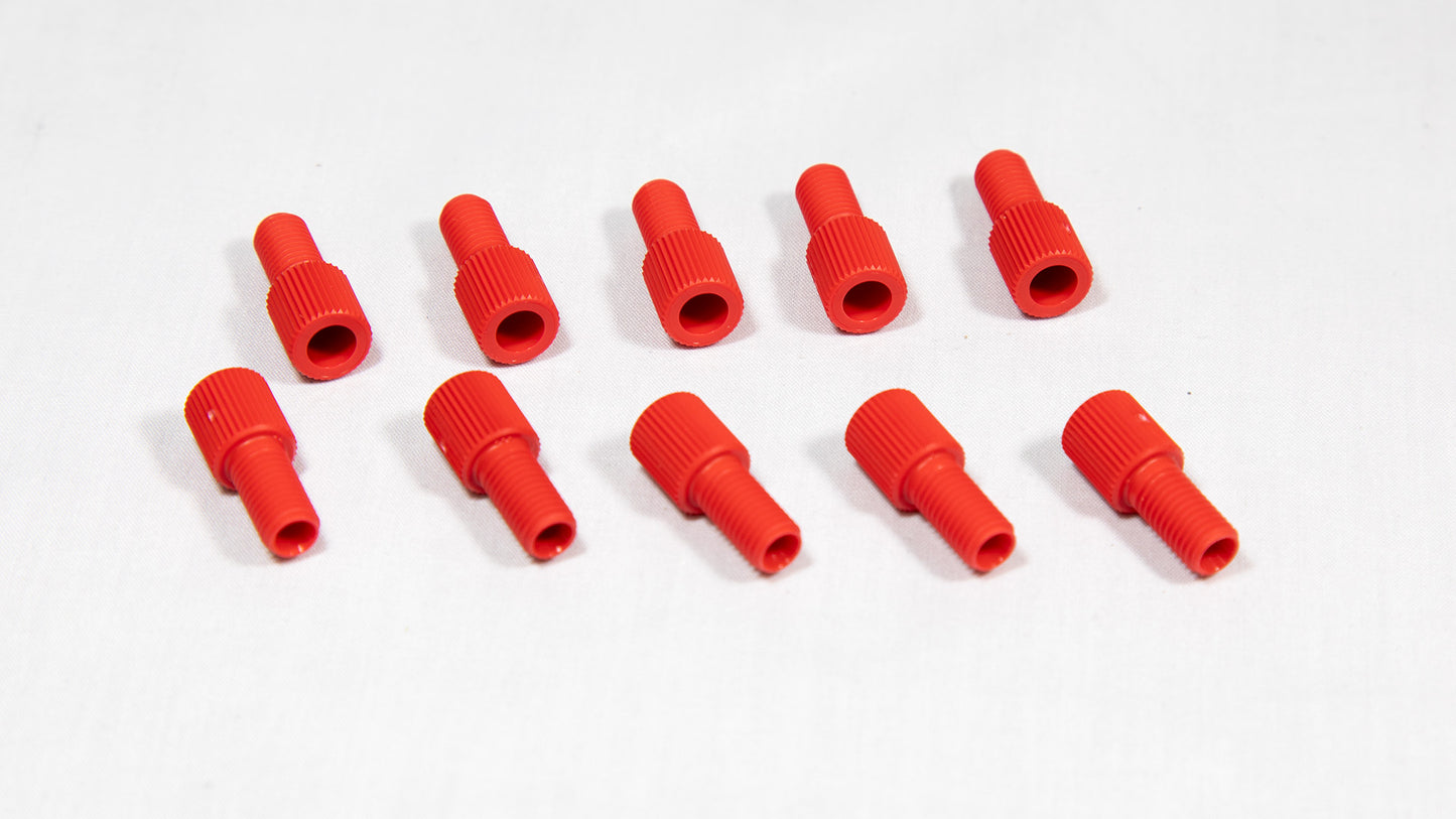 A collection of red plastic threaded fittings arranged on a clean white surface.
