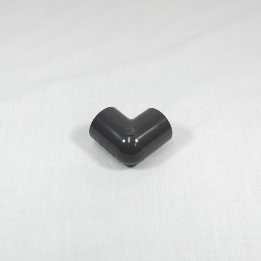 A grey plastic pipe fitting displayed against a white background, highlighting its shape and texture.