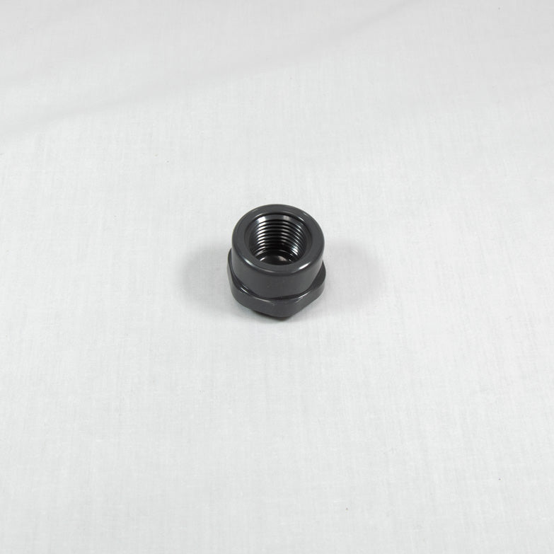 A solitary black plastic nut displayed on a white background.