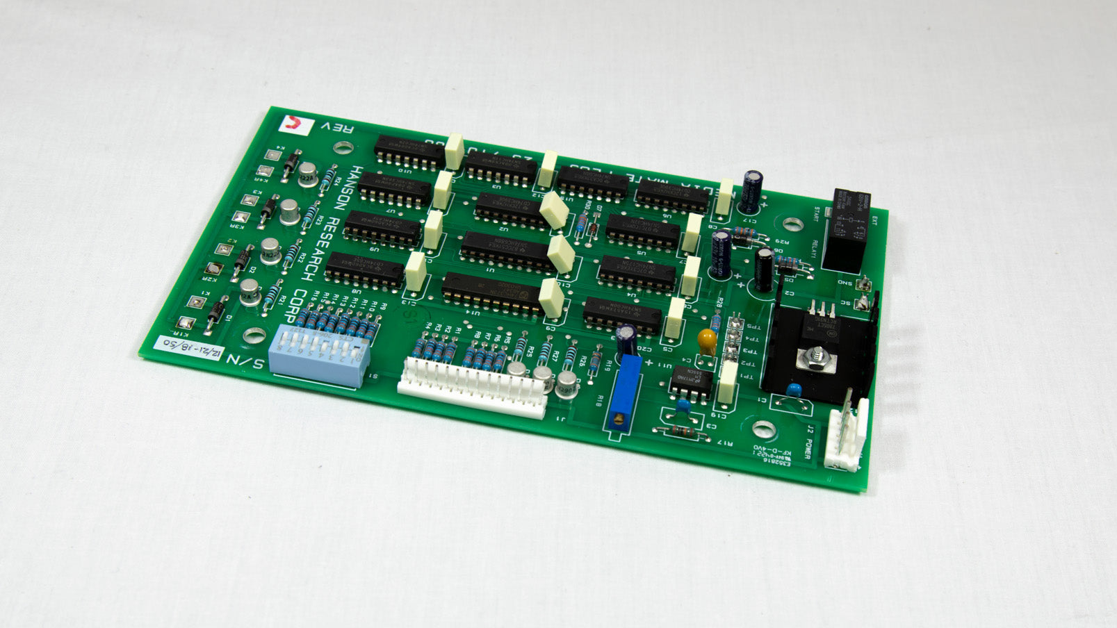 A small electronic circuit board featuring various components like resistors, capacitors, and microchips.