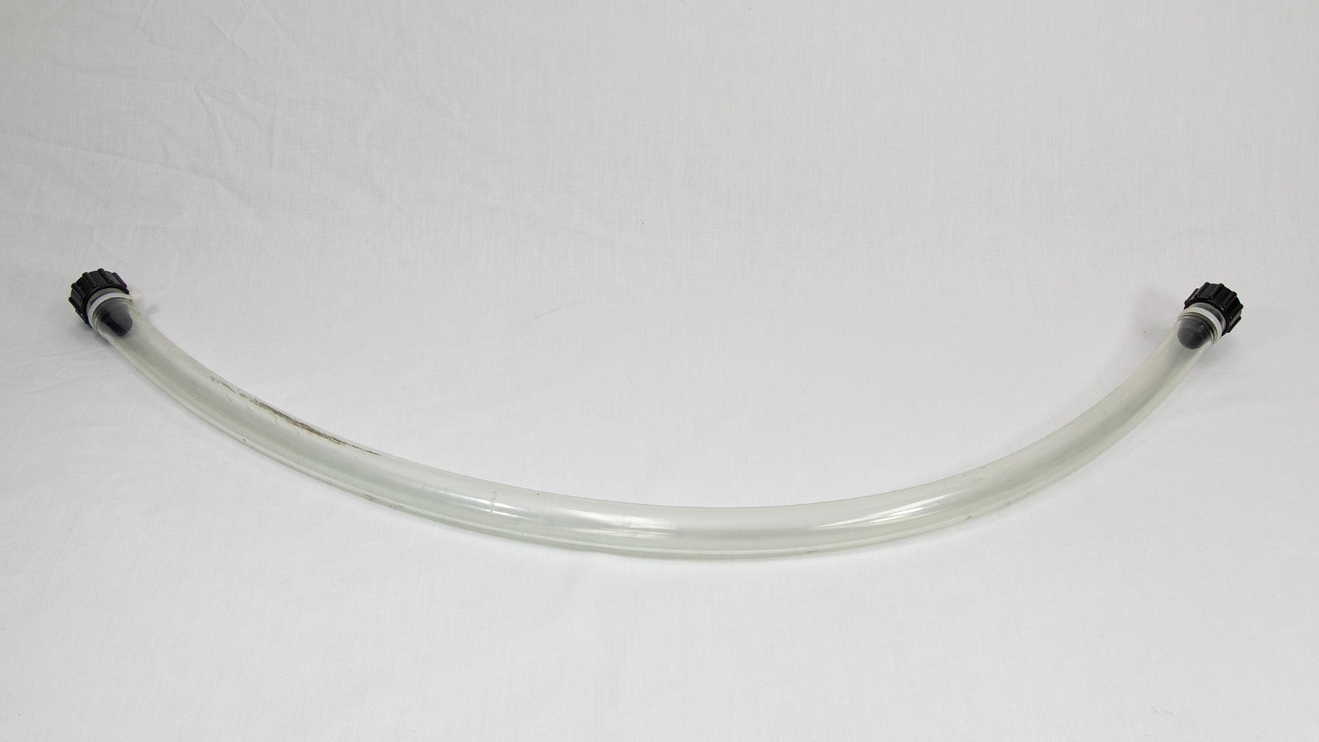 A piece of clear tubing with contrasting black fittings, isolated on a white background.
