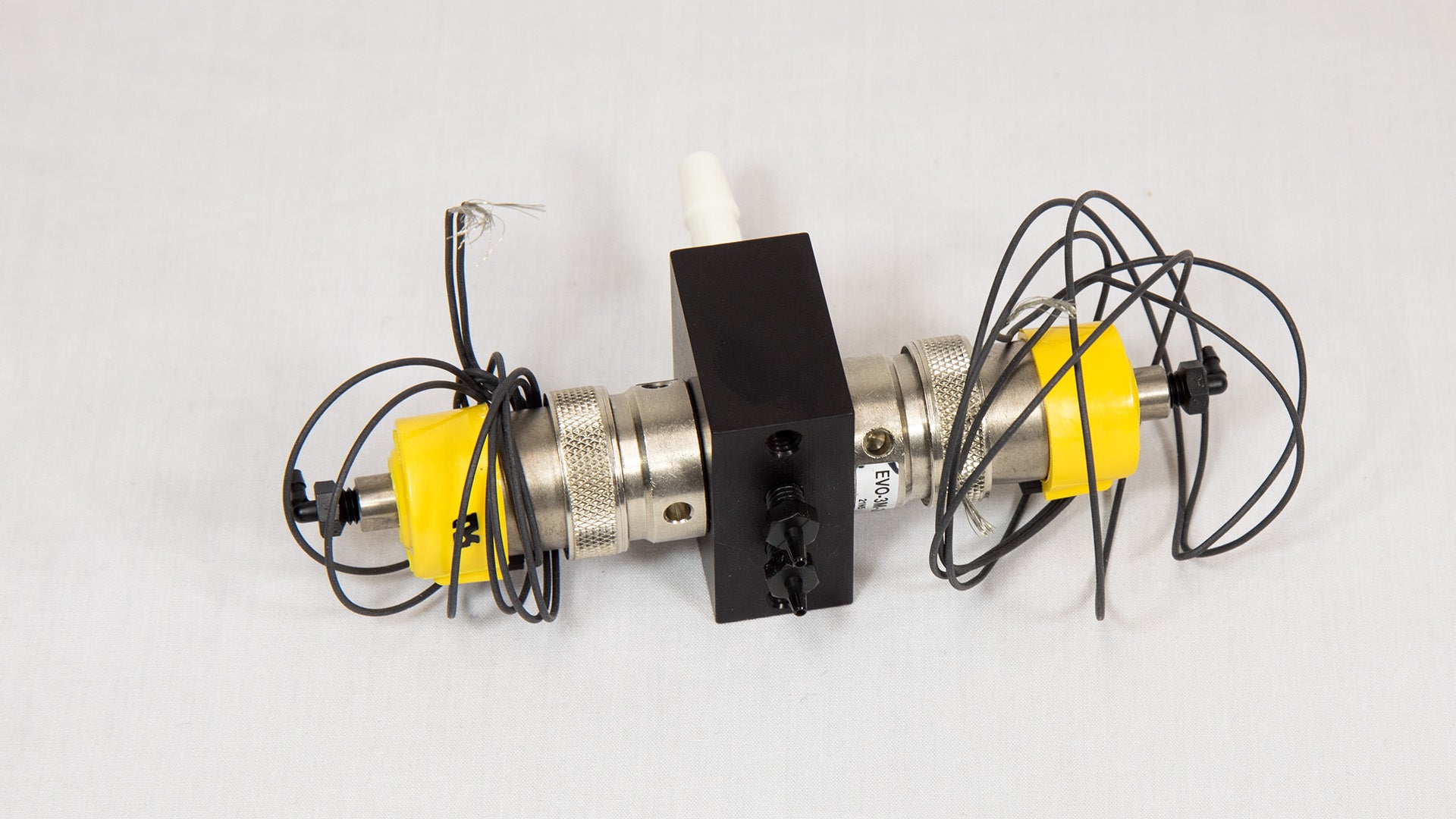 A yellow and black device featuring several attached wires, suggesting its use in a technical or electrical context.