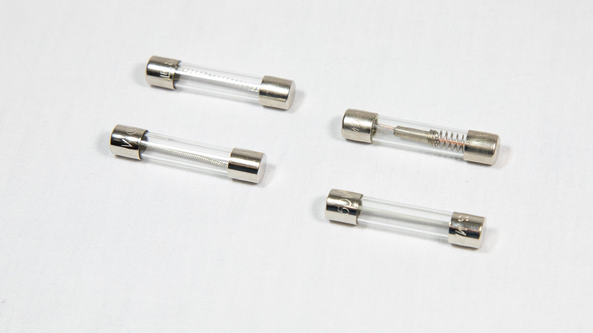 Four distinct electronic fuses arranged on a white surface.