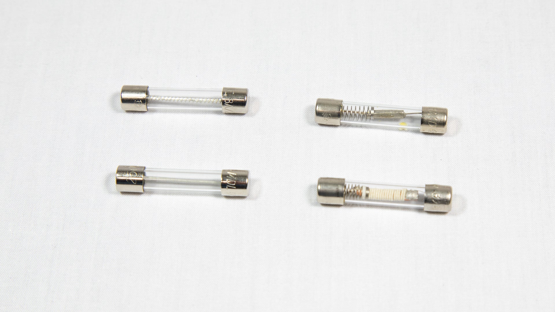 Four distinct electronic fuses arranged on a white surface.
