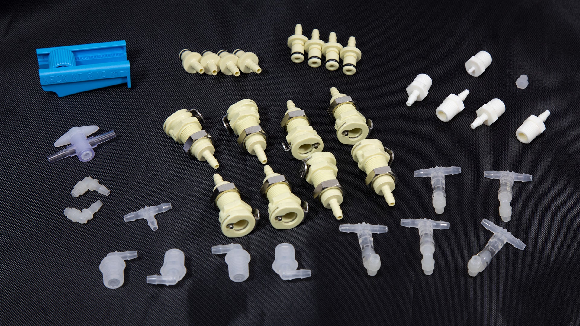 A collection of colorful plastic parts and tools arranged on a black surface, showcasing various shapes and sizes.
