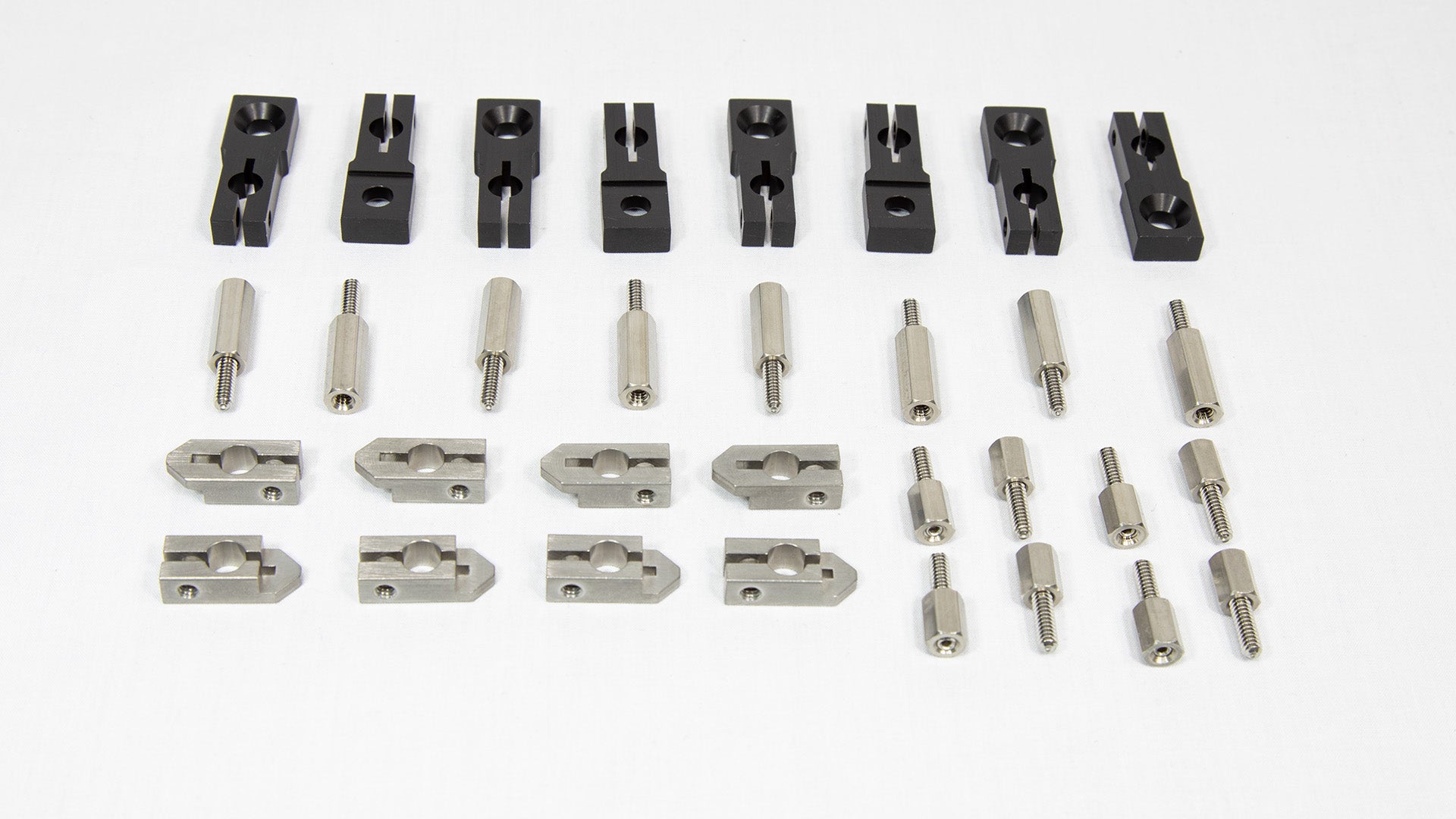 An assortment of metal parts and tools intended for machine assembly, organized on a table.