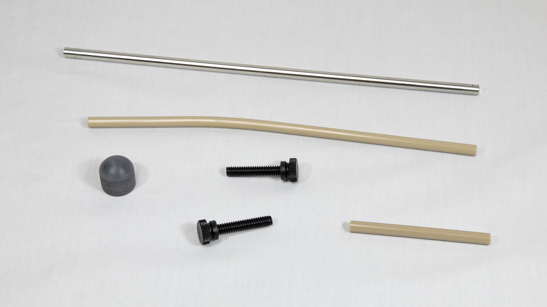 A collection of metal and plastic components, including a pipe, screw, and nut, arranged on a neutral background.