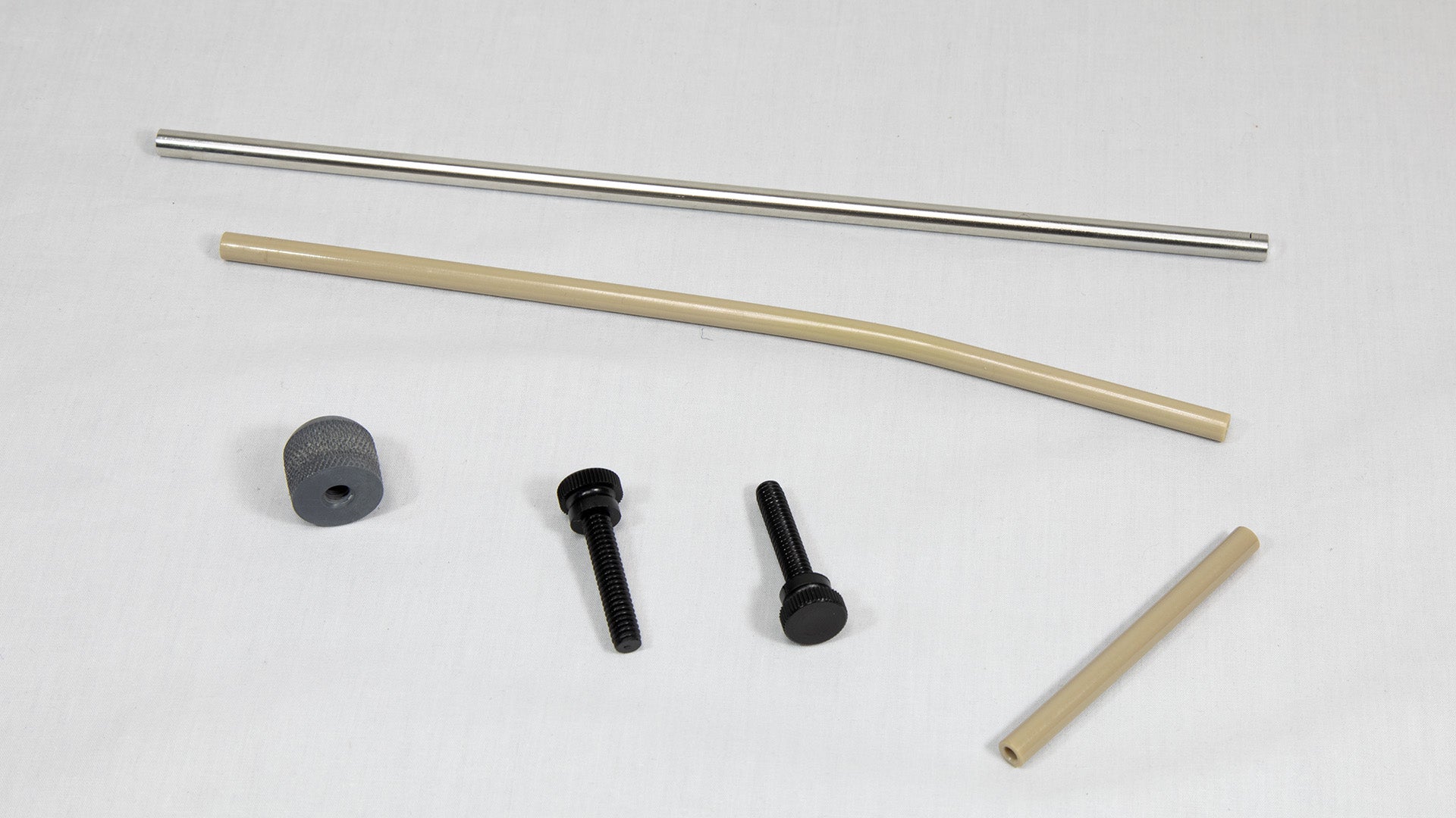 A collection of metal and plastic components, including a pipe, screw, and nut, arranged on a neutral background.