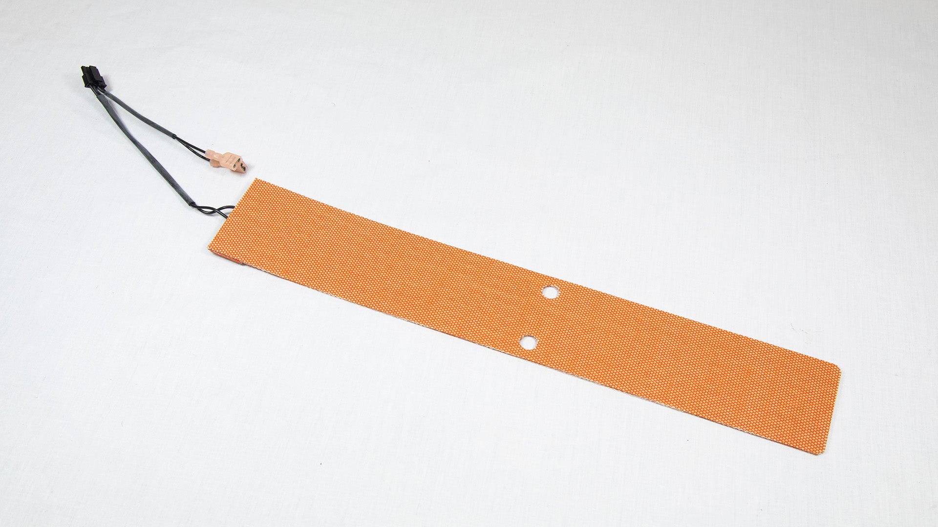 A small orange pad with a wire attached, indicating a functional use in a project.