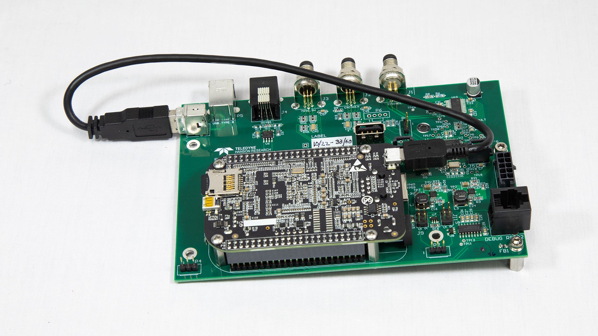 A miniature electronic board featuring an attached USB cable for power or data transfer.