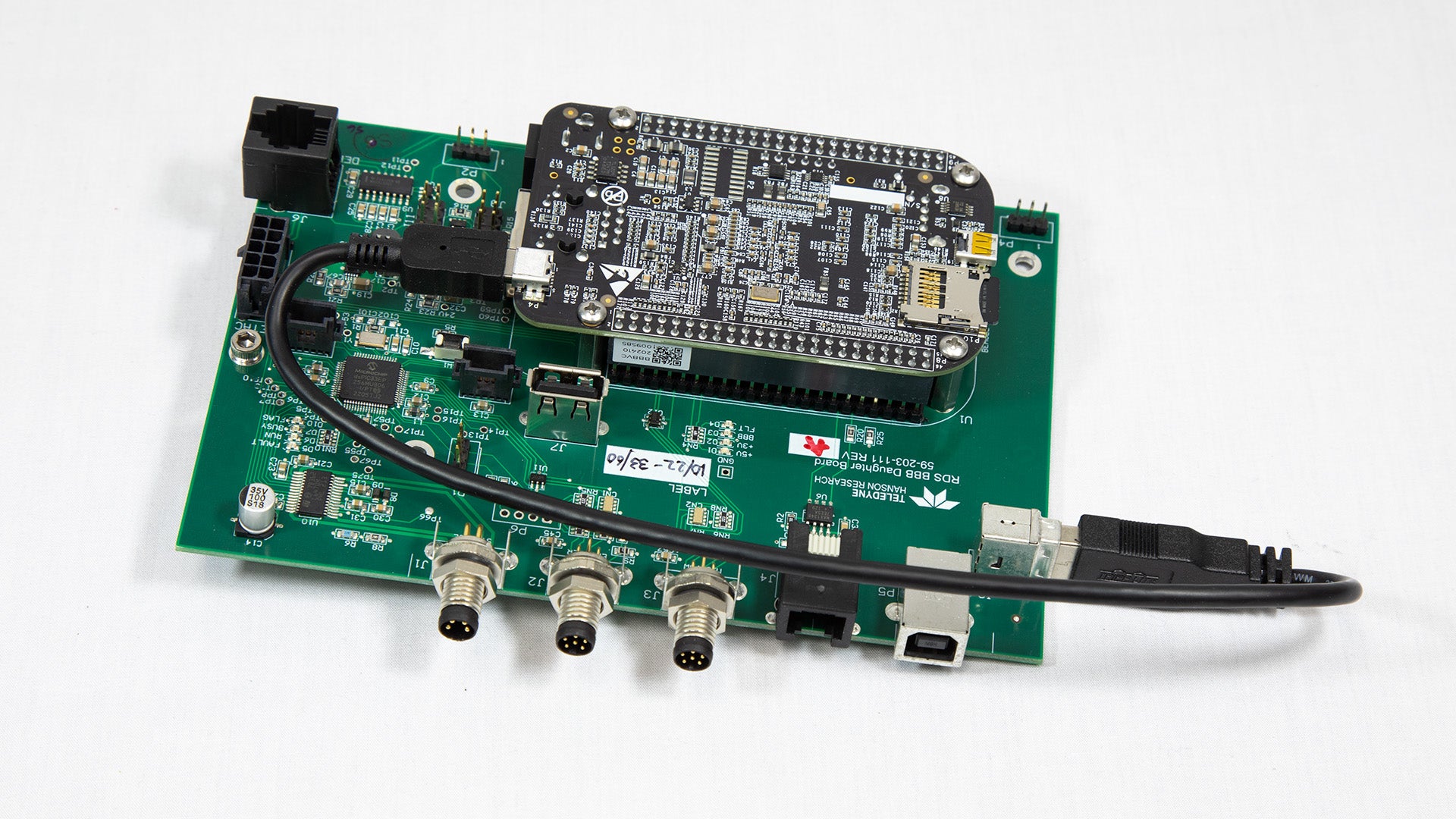 A miniature electronic board featuring an attached USB cable for power or data transfer.