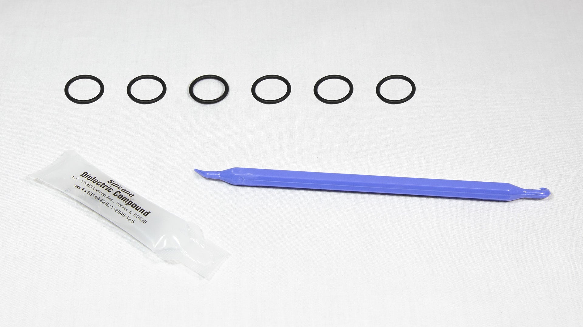 Various rubber o-rings displayed alongside a plastic tube, highlighting their flexibility and vibrant colors.