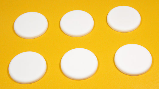 Six white round objects arranged on a bright yellow background.