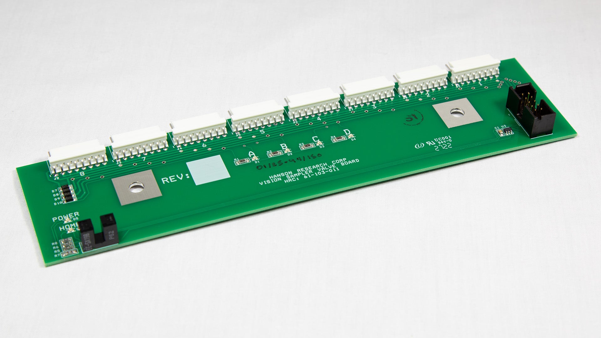 A green electronic circuit board with various components displayed on top.