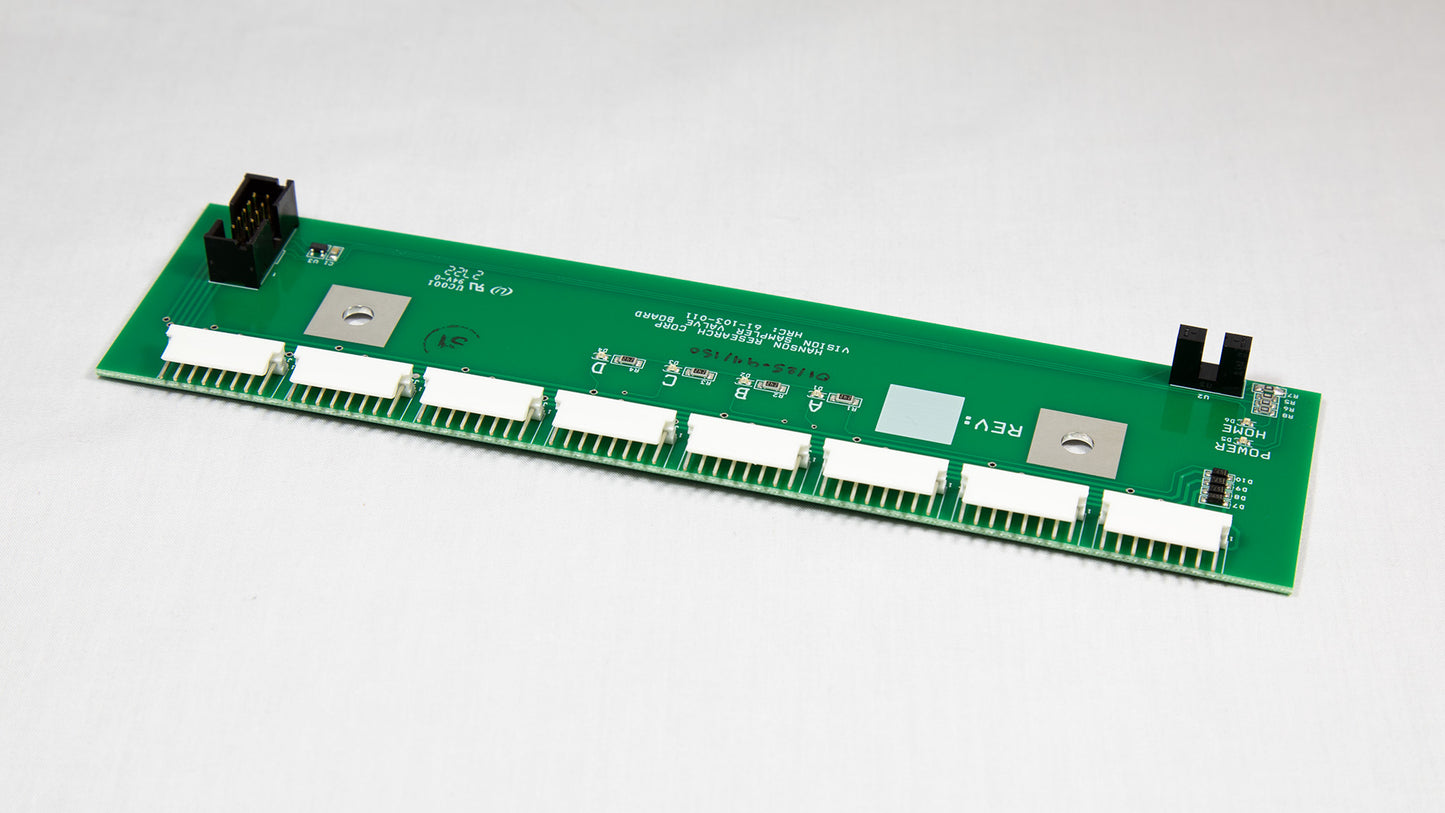 A green electronic circuit board with various components displayed on top.