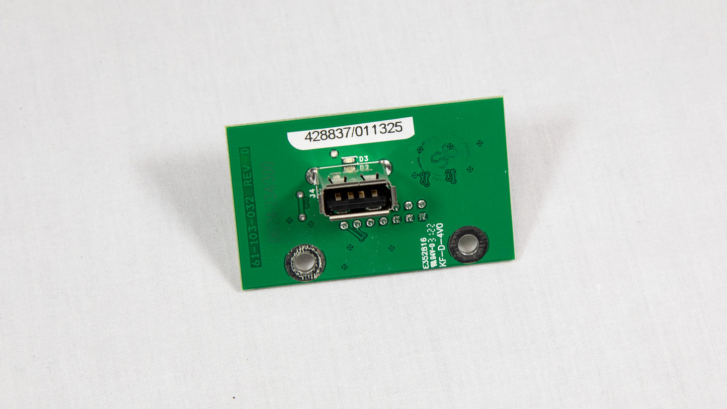 A green electronic circuit board with various components displayed on top.