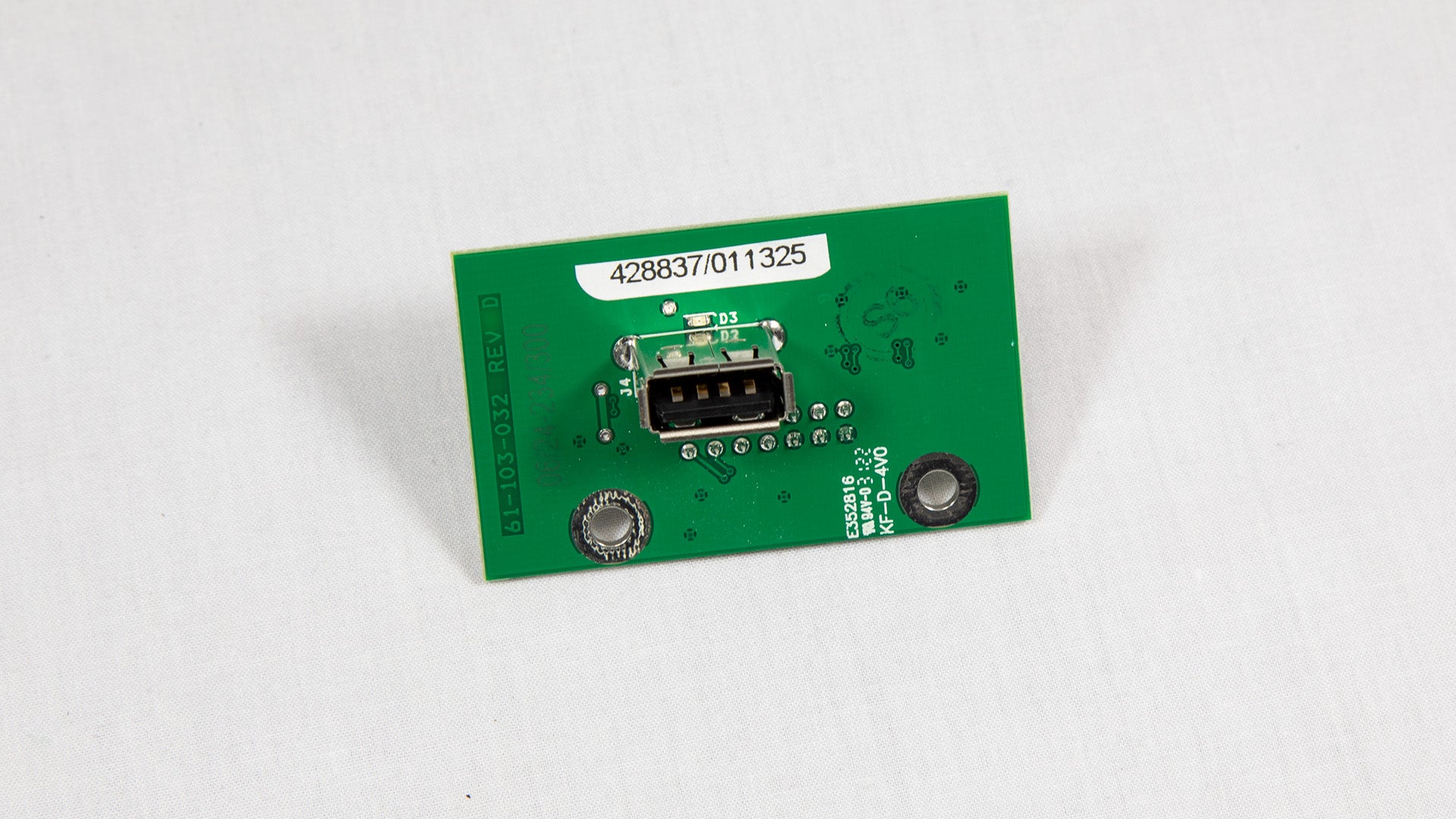 A green electronic circuit board with various components displayed on top.