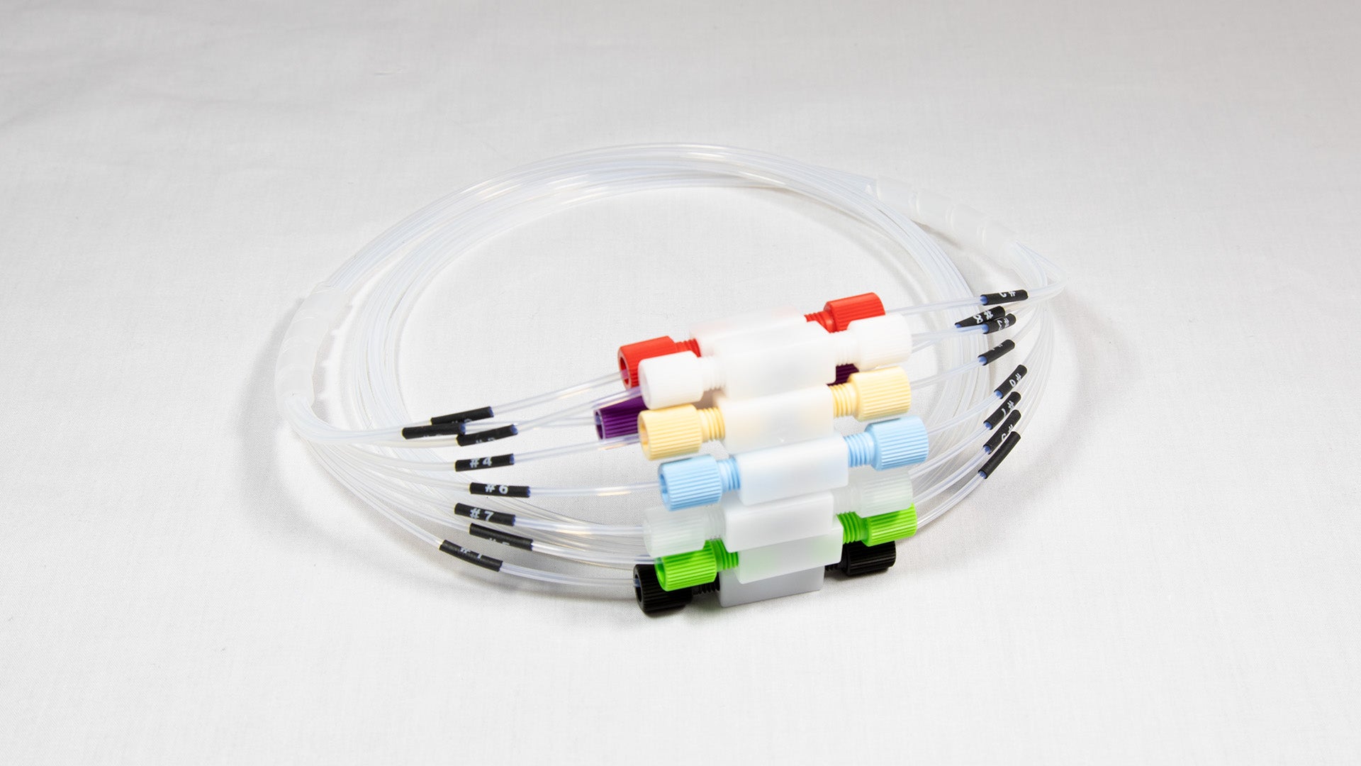 A collection of plastic tubes, each with a unique colored connector, displayed together for visual contrast.