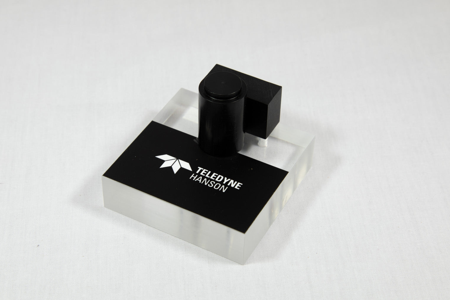 Black and white square box featuring a prominent white logo in the center.