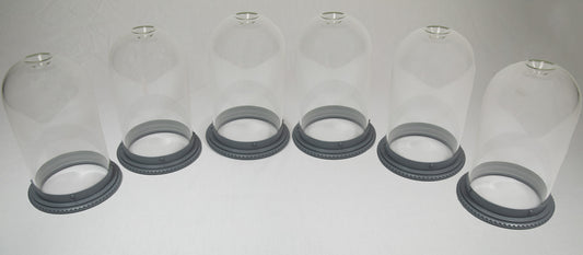 Six clear glass domes resting on black bases, arranged in a row, showcasing a minimalist design.