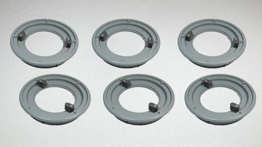 Six gray plastic rings arranged on a white surface, showcasing their circular shape and smooth texture.