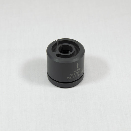 A black plastic cylinder with a prominent arrow indicating direction that includes a small hole.