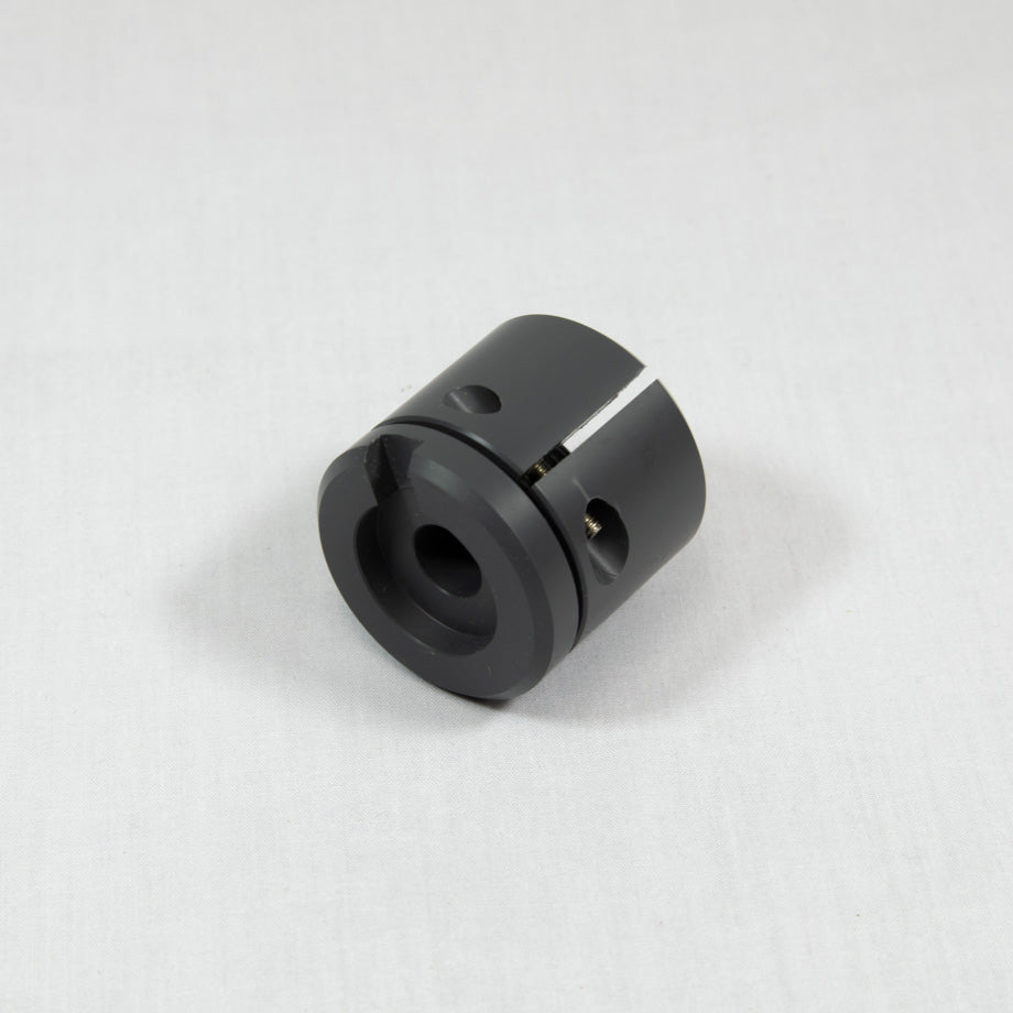 A black plastic cylinder with a prominent arrow indicating direction that includes a small hole.