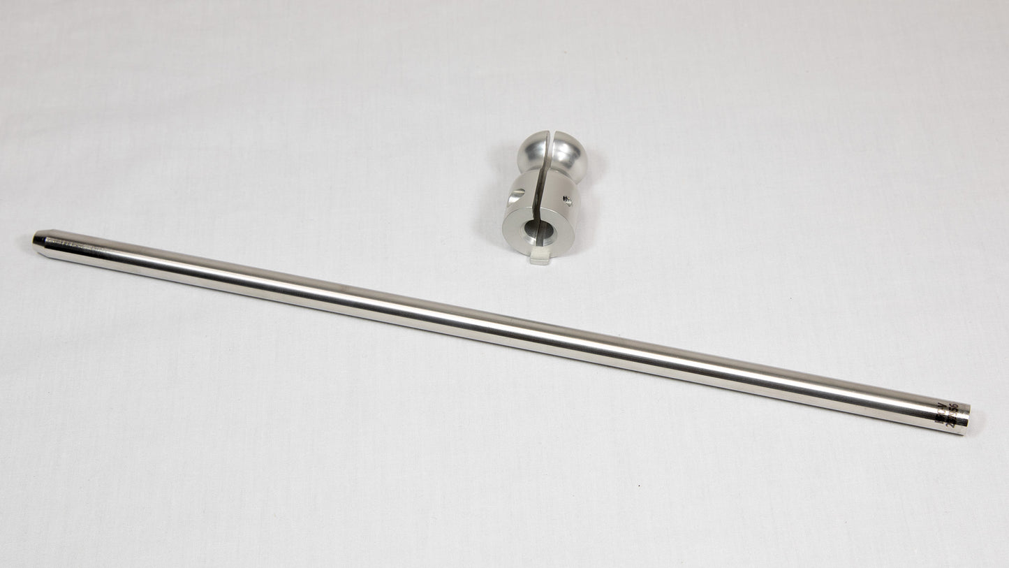 A stainless steel rod placed next to a clamp on a neutral background.